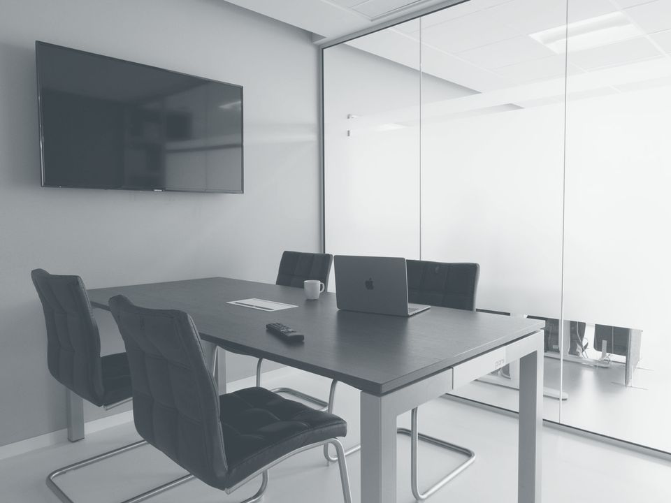 Empty meeting room with glass walls and a wall screen